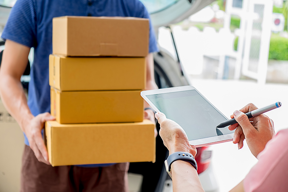 Delivery service courier driver driving with with boxes in hands